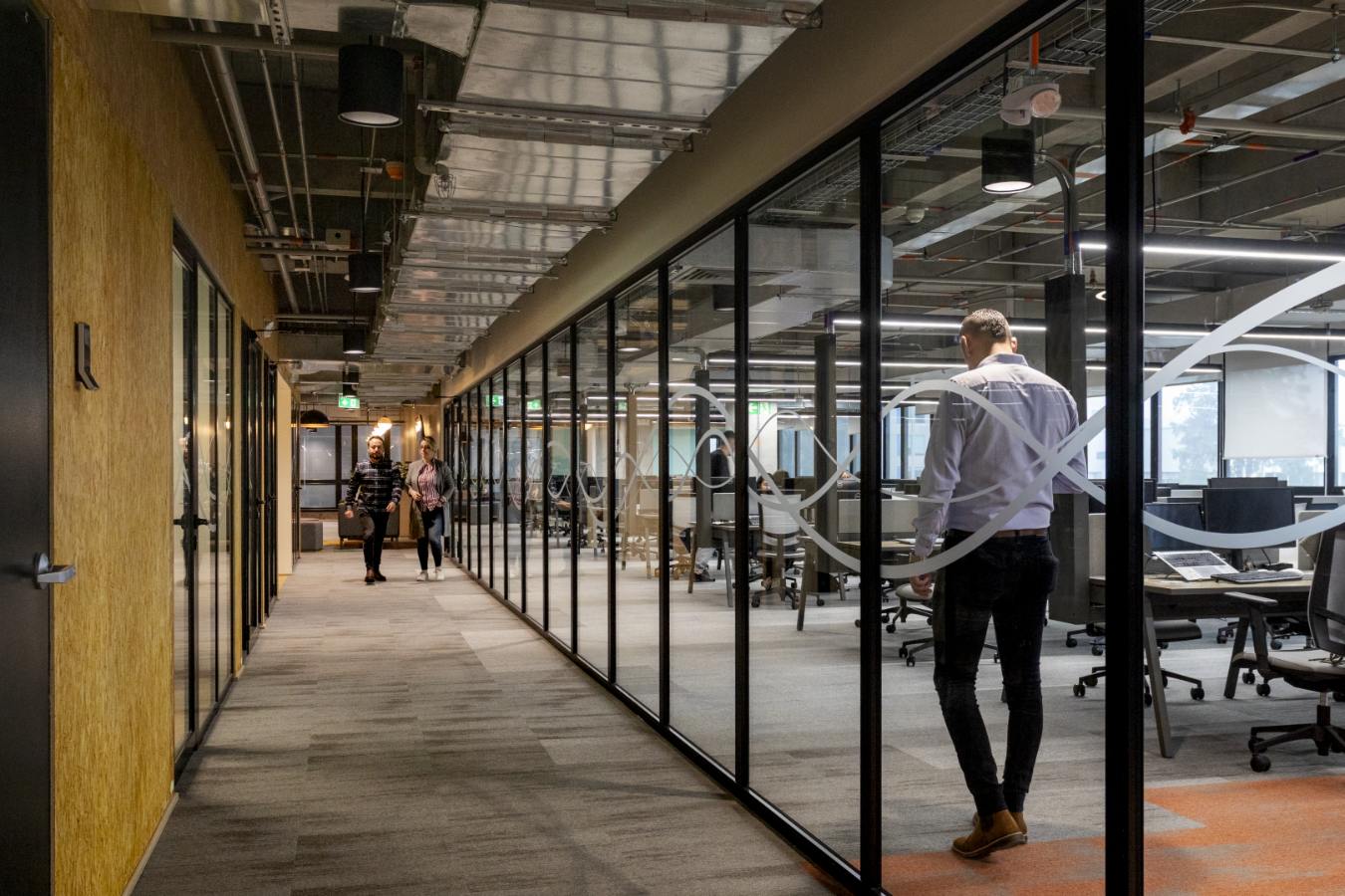 Emapta Offices - Industrial office corridor with glass-fronted meeting rooms and exposed services - Contract Workplaces.jpg